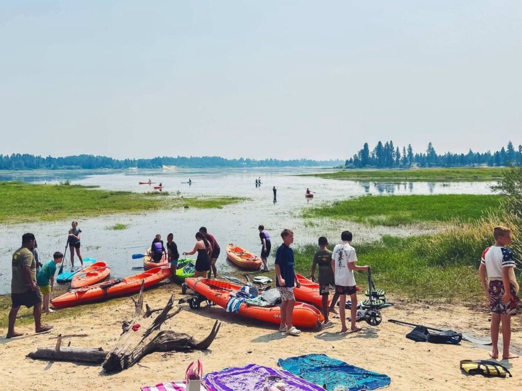 High schoolers launching kayaks and paddleboards at the lake
