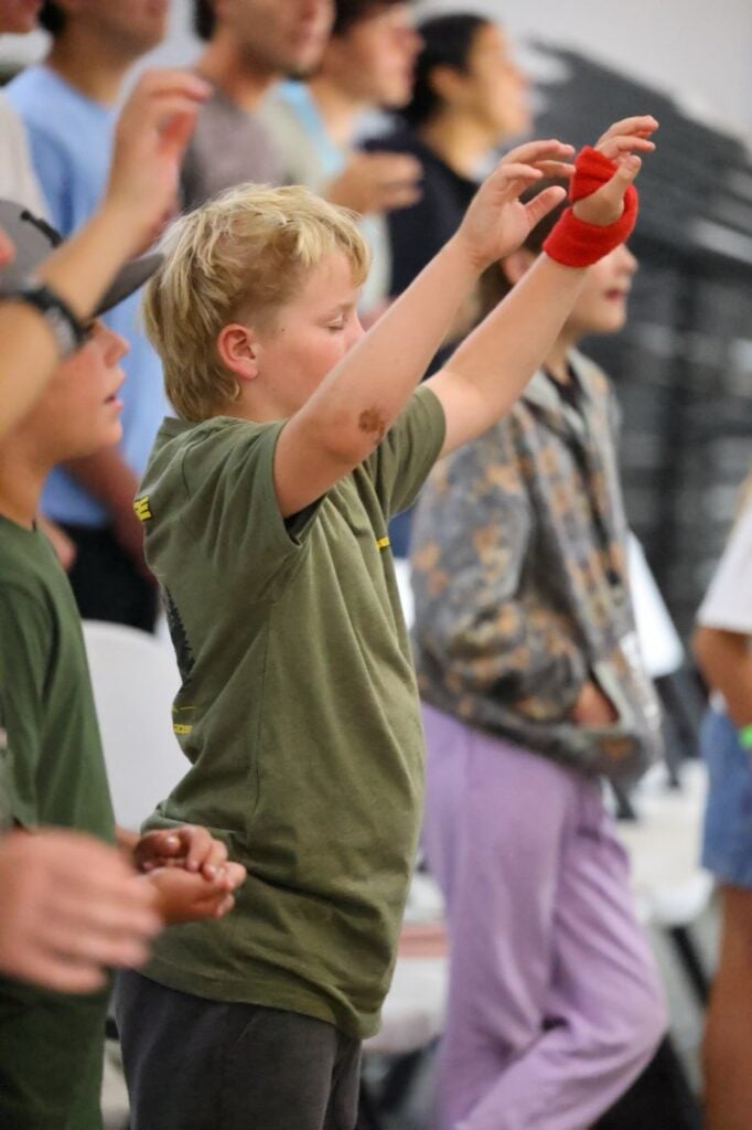 Junior high boy worshiping with hands raised